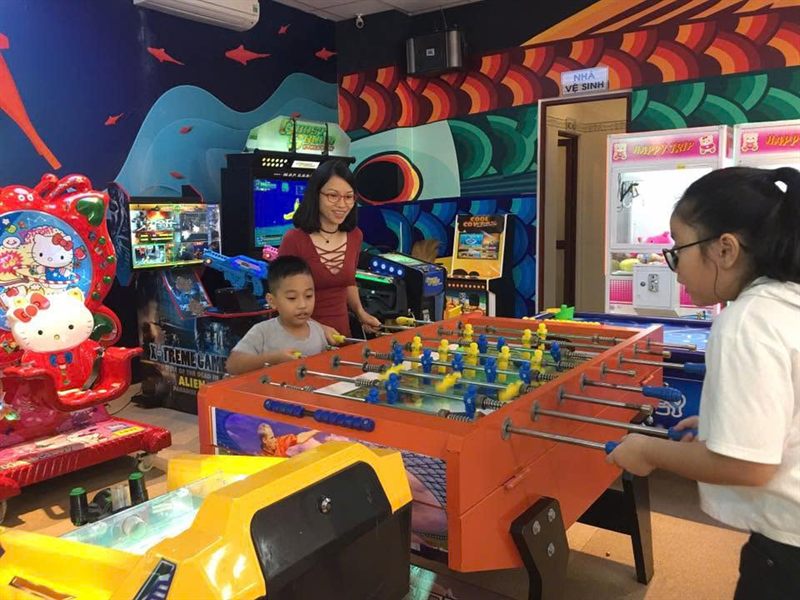 Mẹ và các con chơi bi lắc trong khu trò chơi.
